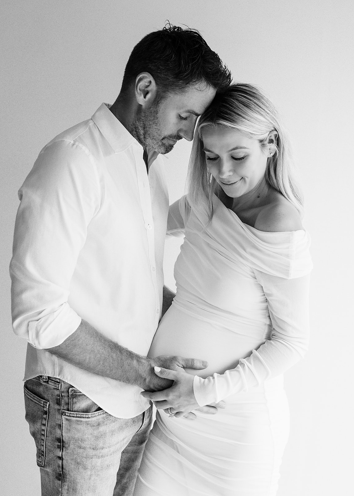 Mom and Dad holding pregnant belly during maternity photoshoot